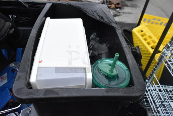 Three Slim Jim poly trash cans filled with assorted items including a white container and green lid cup.