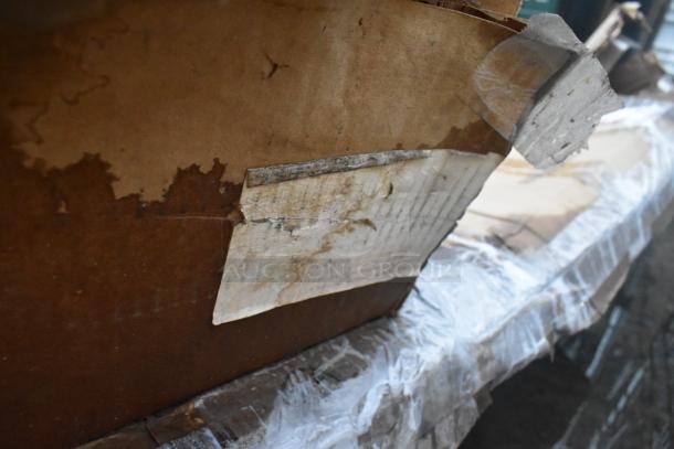 Damaged cardboard box showing wear, containing 5 various brand new scratch and dent items, including a furniture dolly.