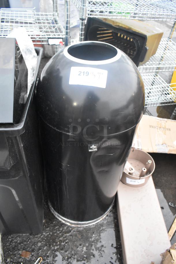 Black metal trash can shell, cylindrical shape, glossy finish, minor scuffs. Label reads "WHITE" and displays "219 QTY 1".