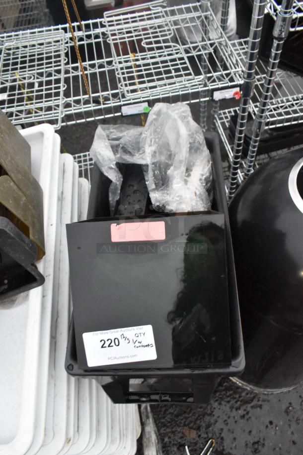 Black Poly Slim Jim Trash Can with contents, shows a label marked "220 lbs." Includes visible plastic wrapping inside.