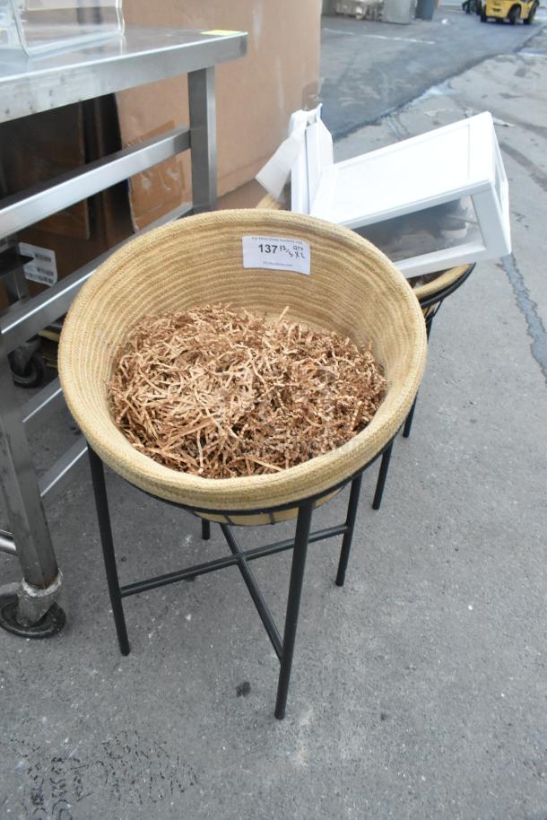 Black metal stand holding a woven basket filled with shredded material, auction label marked "137."