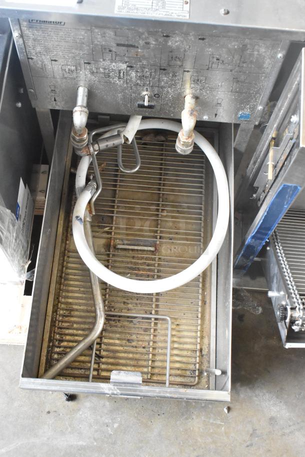 Pitco Frialator stainless steel fryer oil filtration system on casters, visible wear, connected pipes and hose, control panel.