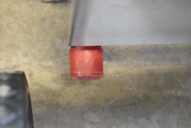 Close-up of a red protective cap on the 48" Cooking Performance Group gas griddle, model 351GTCPG48NL. Brand new, some scratches.