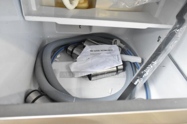 Scotsman UC0918GAX-1A ice machine components inside, showing hoses and installation guides; stainless steel, new condition.