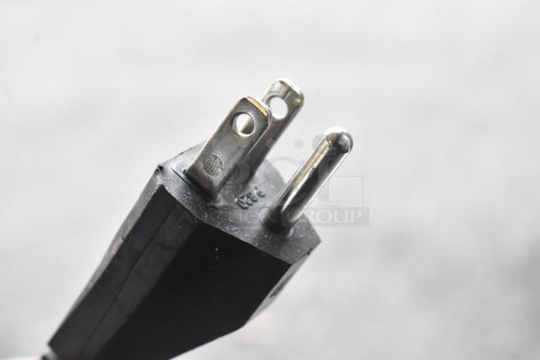 Close-up of a power plug's metal prongs from a Scotsman UC0918GAX-1A ice machine. Focus on prongs' condition.