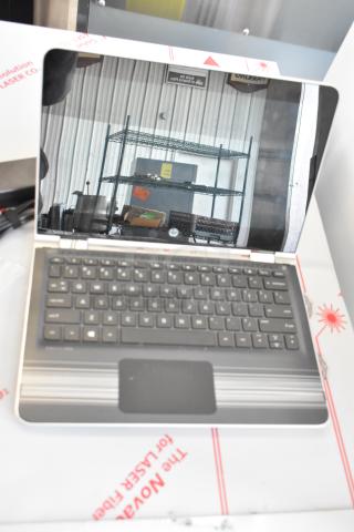 HP m1-u001dx laptop with visible screen reflection and keyboard, includes charger, in good condition.