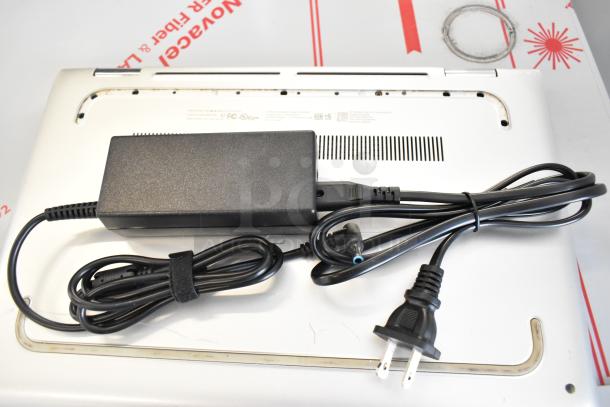 HP m1-u001dx laptop with charger, silver finish, visible ports and cooling vents, in good condition.