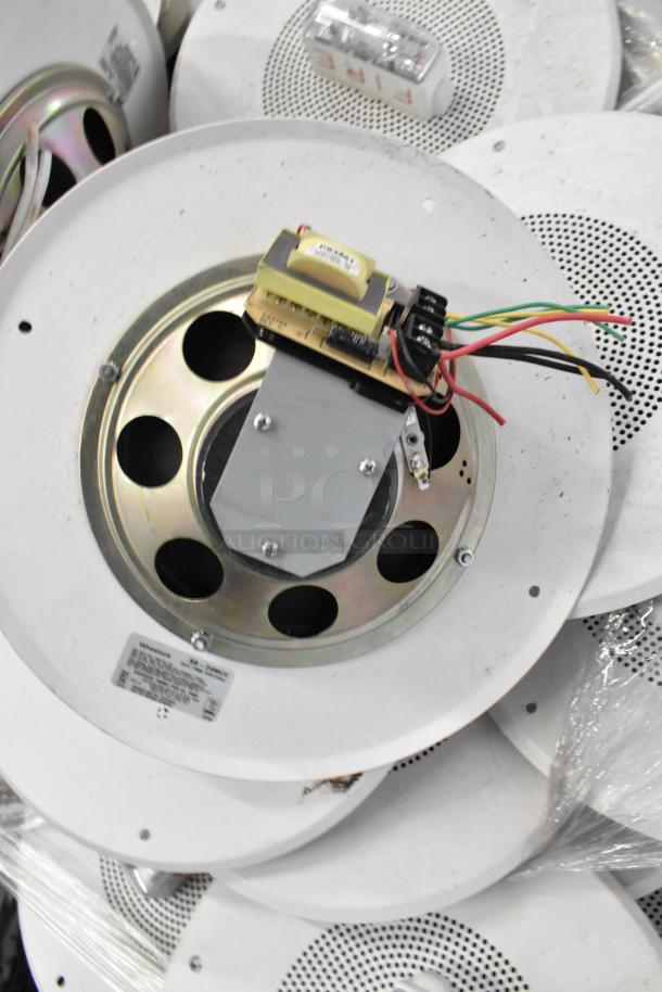 Pallet lot of Wheelock S8-24MCC speaker enclosures with fire alarm lights, featuring circular design, visible wiring, and labels.