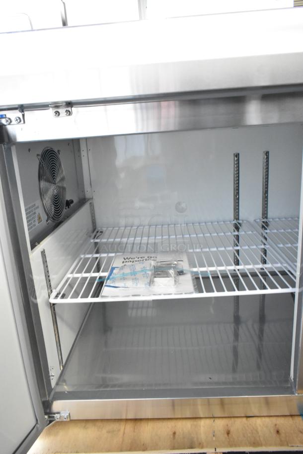 Brand new Avantco 178APPT71HC stainless steel pizza prep table, 115V, with slight scratches and dents, interior shelving shown.