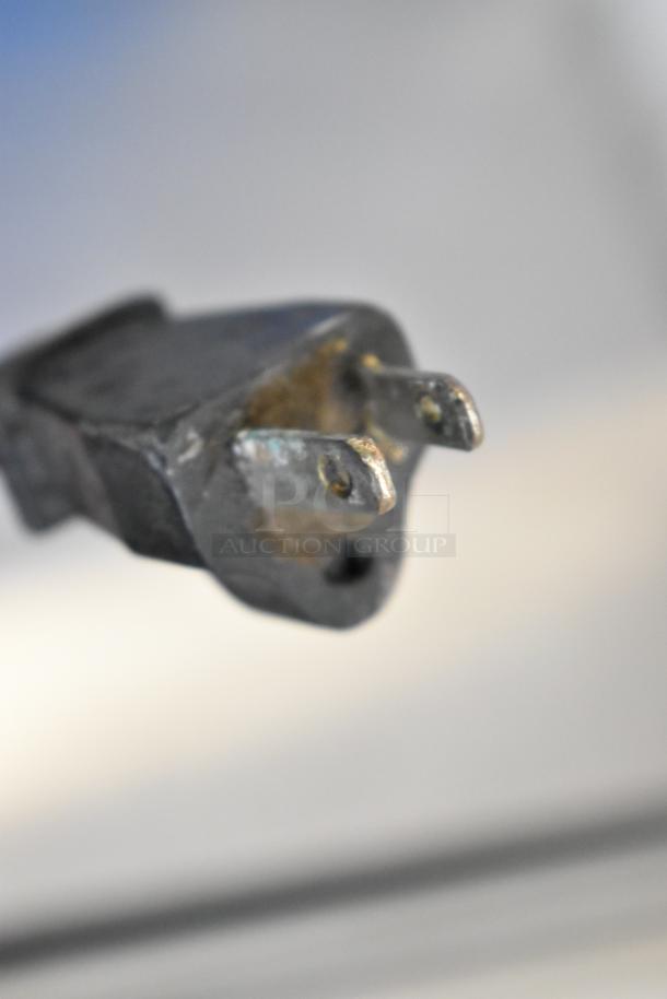 Close-up of a worn plug for a Waring WSB immersion blender, 120 volts, 1 phase. Plug shows signs of use.
