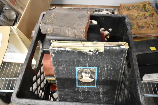 Crate containing a worn Holy Bible, vintage photo album, and assorted items in mixed condition.