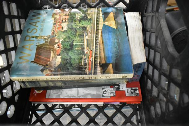 Crate containing "Warsaw: A Portrait of the City" book, other assorted books, and a black Technics speaker visible.