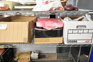 Auction tier lot with various items on shelves including ceramic containers, state plates, pink ring pool, and vintage items.