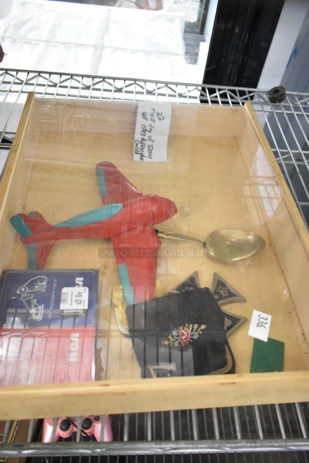 A tier lot with various items including a red model airplane, gold spoon, embroidered pouch, and blue boxed item.