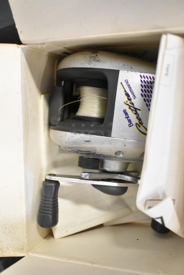 Shimano Bantam Certrifuge CP-200A fishing reel with visible scratches, spooled with line, boxed with documents.