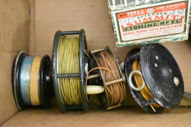 Assorted vintage fishing reels, including Pflueger Summit. Visible wear, boxed label indicating model 1993-L, line capacity.
