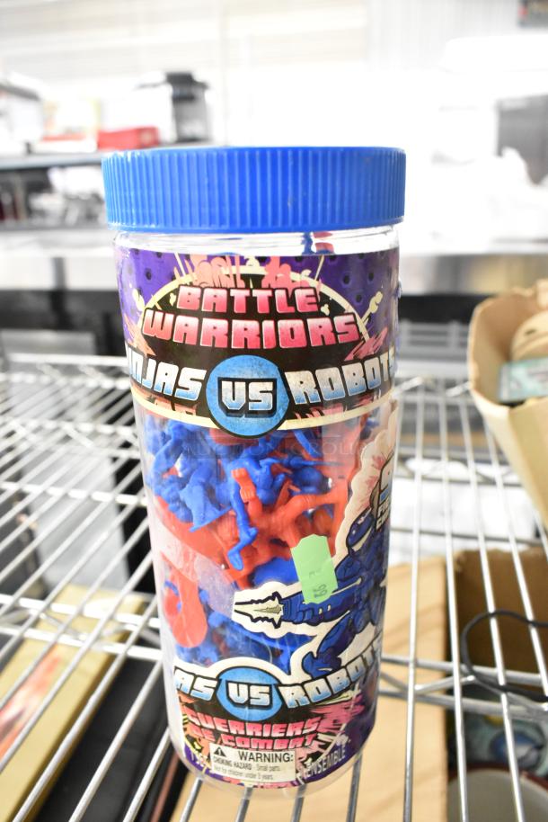 Battle Warriors "Ninjas vs Robots" toy container with red and blue figures. Label indicates small parts warning.