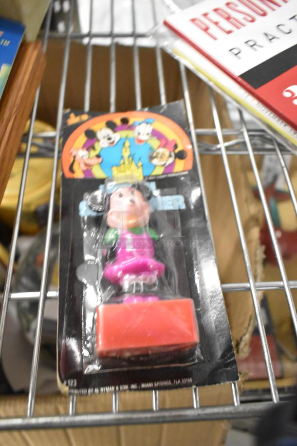 Tier lot featuring a vintage Disney Pez dispenser in original packaging, alongside magazines. Good condition, collectible value.