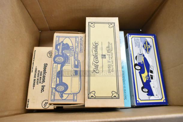 Six collectible vehicle figurines in original boxes, including 1957 Chevy Bel Air, 1952 Chevrolet Pickup, 1951 Ford Pickup, 1932 Ford Panel Truck, 1926 Mack Stake Body. Vintage condition.