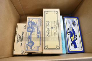Six collectible vehicle figurines in original boxes, including 1957 Chevy Bel Air, 1952 Chevrolet Pickup, 1951 Ford Pickup, 1932 Ford Panel Truck, 1926 Mack Stake Body. Vintage condition.