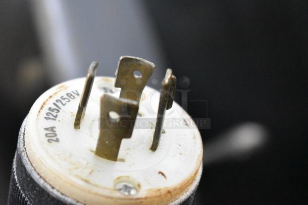 Close-up of a plug, showing metal prongs and markings indicating 20A, 125/250V. Part of a Hobart L 800 mixer setup.