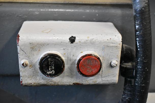 Metal Commercial Floor Style Dough Sheeter control panel with start and stop buttons, showing signs of wear.