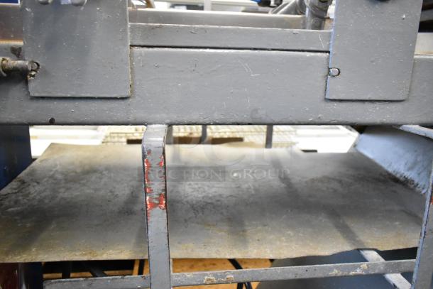 Metal commercial floor style dough sheeter, industrial condition, visible wear, sturdy construction, ideal for bakery use.