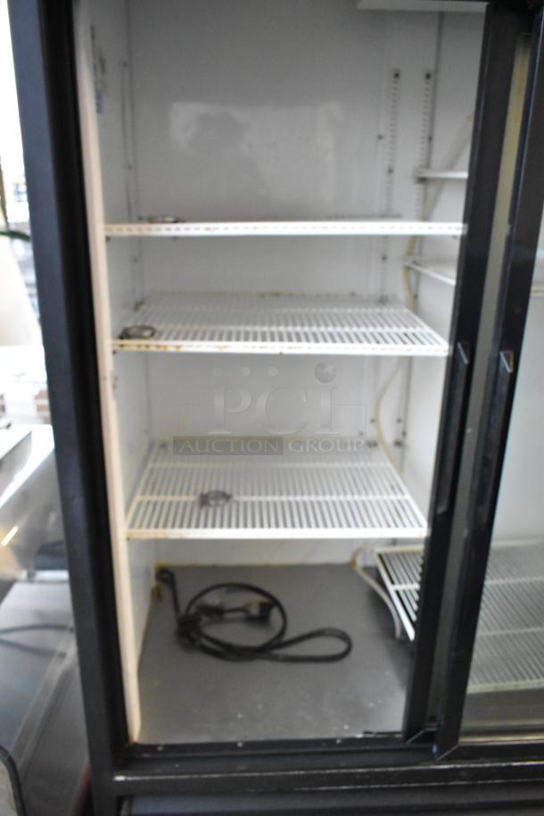 True GDM-69 three-door cooler merchandiser with poly-coated racks, 115V, 1 phase, metal frame, good condition.