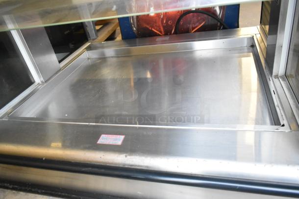 Henny Penny HI-3 stainless steel heated display case, 120/208 volts, 1 phase, clean interior, visible caution label.