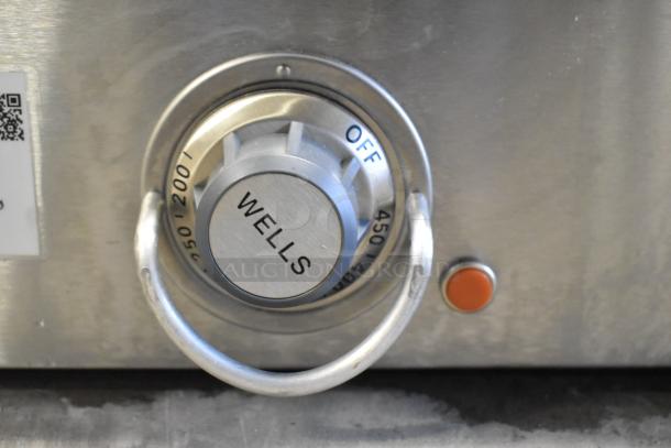 Wells G19 stainless steel griddle knob with temperature settings and red button, showing brand name.