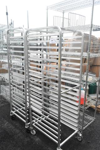 Two metal commercial pan transport racks on casters, used condition, suitable for bakery or kitchen use, with shelving slots.