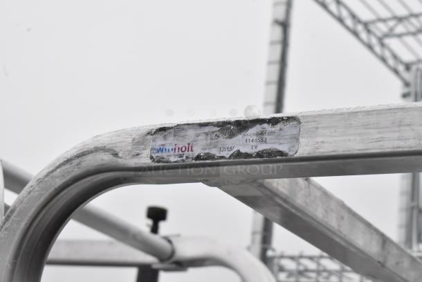 2 metal commercial pan transport racks on casters, visible wear, Winholt label, ideal for kitchen storage and mobility.