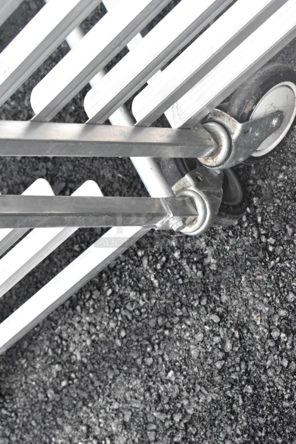 Two metal commercial pan transport racks on casters, durable, suitable for heavy-duty use, good condition.