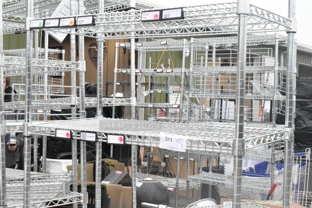 Chrome finish 5 tier wire shelving unit in excellent condition, includes visible tags and labels. Buyer must dismantle.