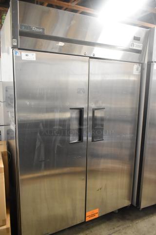 True TG2R-2S-HC stainless steel 2-door reach-in cooler with poly-coated racks. Needs door reattachment. 115V, 1 phase.
