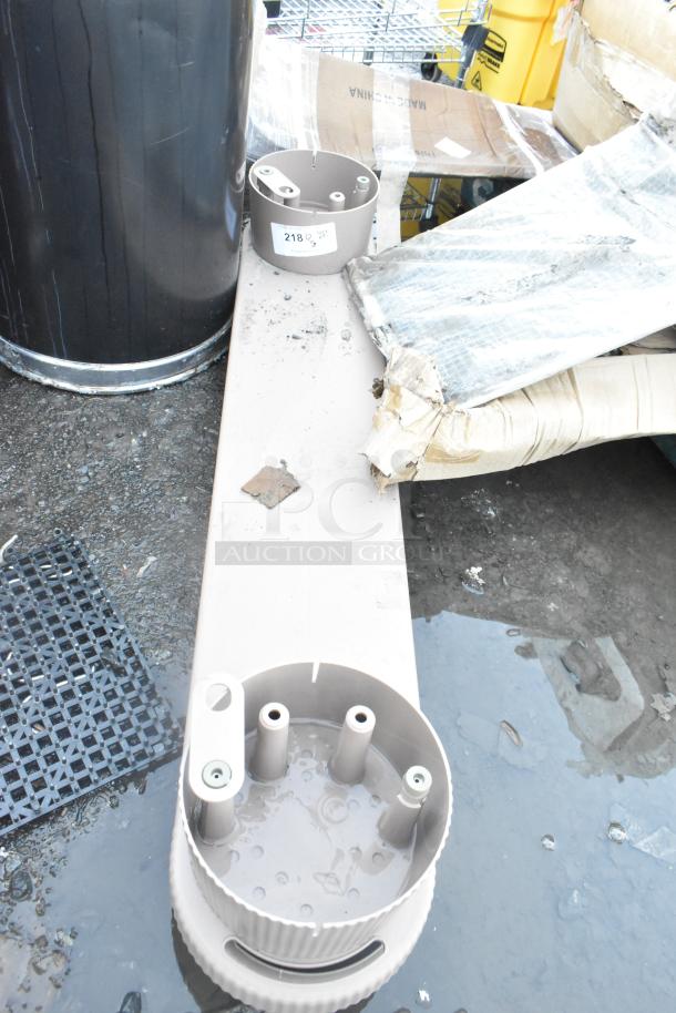 Two poly units with circular fittings, used condition, placed on a wet surface with packaging materials. Label marked "218" visible.