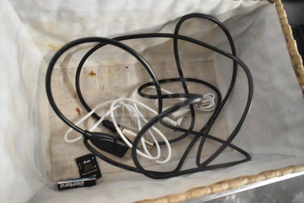 Basket containing assorted cables, a 4GB SDHC memory card, and a Duracell AA battery. Potential mixed electronic items.