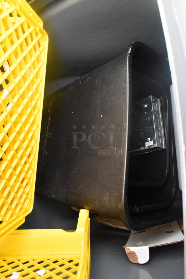 Rubbermaid gray poly trash can with contents, including yellow caddies. Good condition, ideal for organizing.