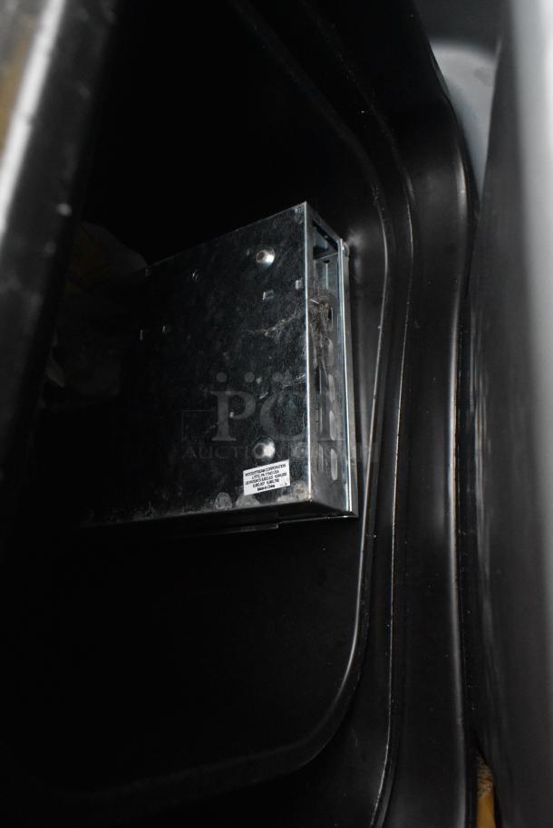 Rubbermaid gray poly trash can with metal caddy inside, showing some wear. Suitable for storage or waste disposal.