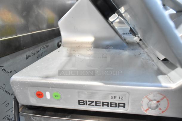 Bizerba SE 12 US metal countertop meat slicer with built-in blade sharpener. Featuring stainless steel finish, model and brand label visible.