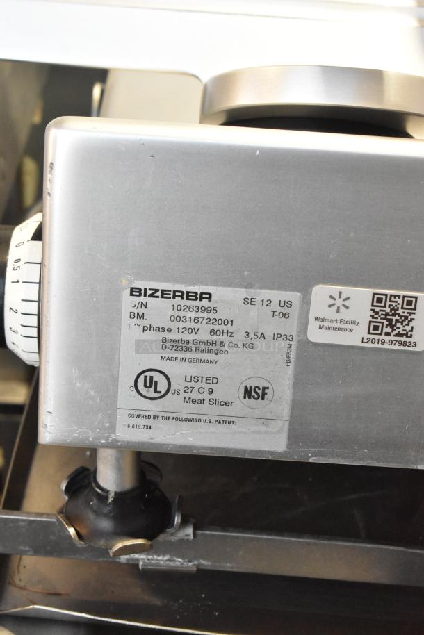 Bizerba SE 12 US commercial meat slicer with blade sharpener, shown on stainless steel stand. Label indicates 120V, 1 phase. Made in Germany.