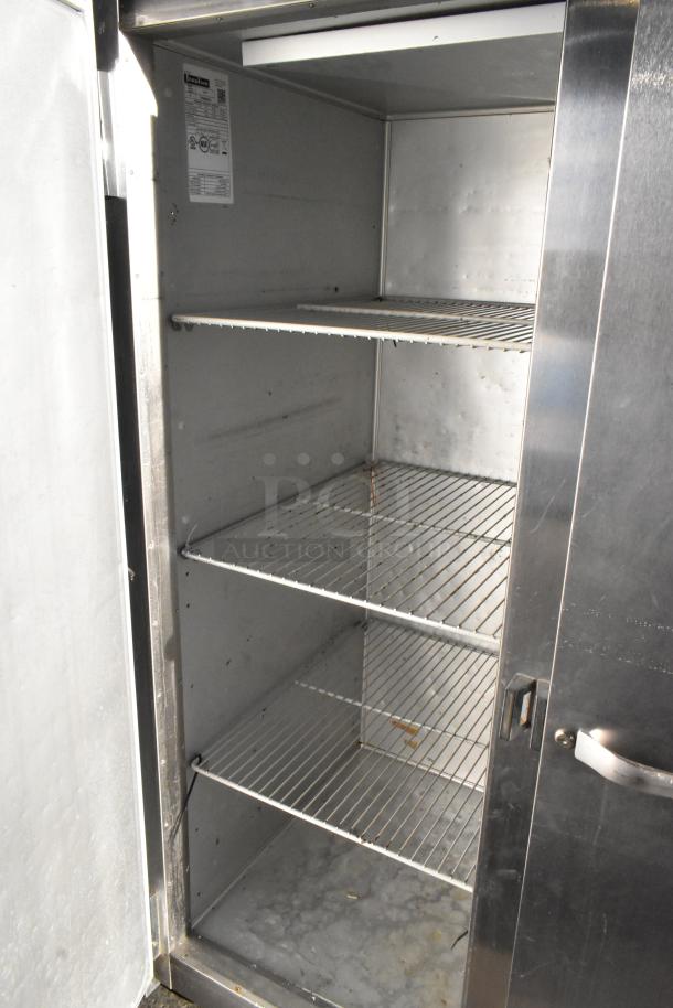Traulsen G30010 stainless steel 3-door reach-in cooler with racks, commercial use, 115 volts, 1 phase, tag visible.