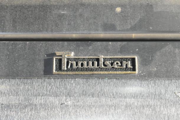 Traulsen G30010 logo on stainless steel commercial cooler. 3 doors, includes racks, operates at 115 volts, 1 phase.