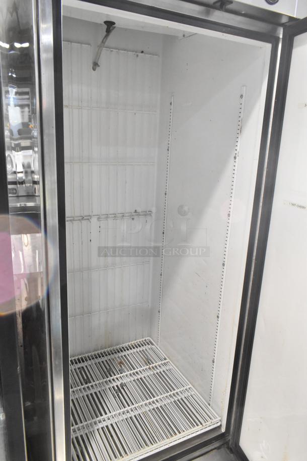 True T-23F stainless steel commercial freezer with single door. Interior shows shelving and electrical specifications: 115 Volts, 1 Phase. Visible wear noted.