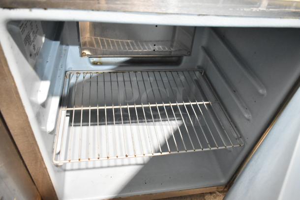 Delfield 406CA-DD1 stainless steel undercounter cooler, single door, commercial casters, 115V, showing interior shelves.