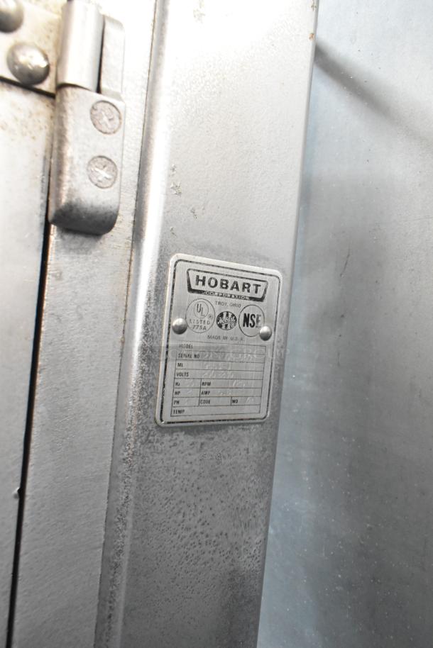 Hobart 5614 metal meat saw, commercial floor style. Features label with model info, 200-230V, 3 phase. Visible wear.