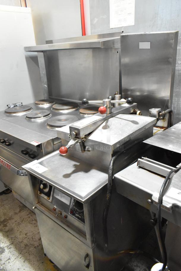 Henny Penny stainless steel electric pressure fryer with commercial casters, 220 volts, 3 phase, floor style, used condition.