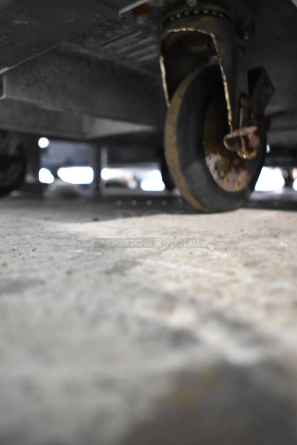 Close-up of a Metro C519-CFC-4 heated holding cabinet's caster showing signs of rust. Model is on metal commercial casters.