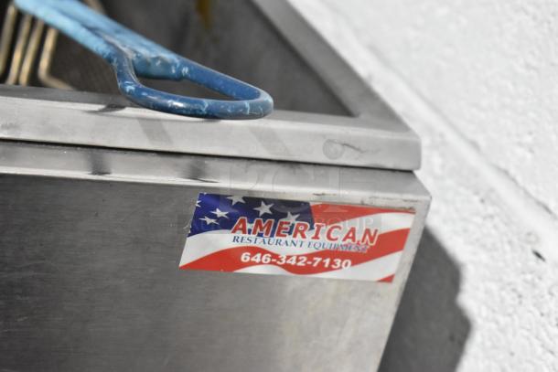 Stainless steel commercial deep fat fryer with two metal fry baskets, featuring a label from "American Restaurant Equipment."