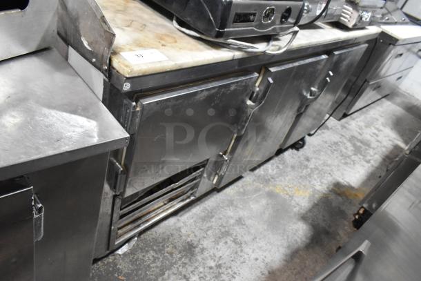 Leader LB72 stainless steel commercial 3-door work top cooler on casters, 115 volts, 1 phase, showing signs of wear.